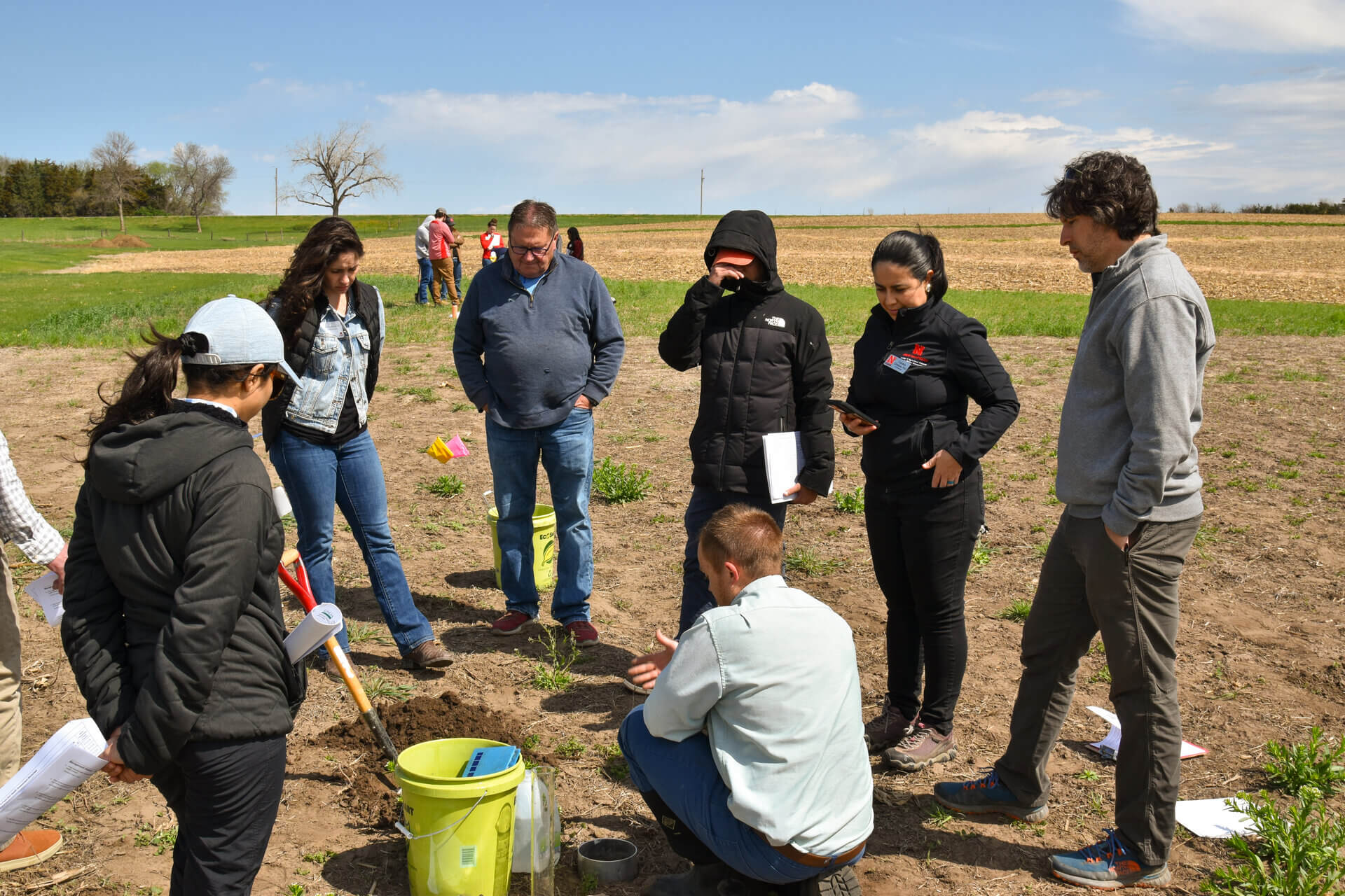 Group evaluating soil samples in field at ENREEC