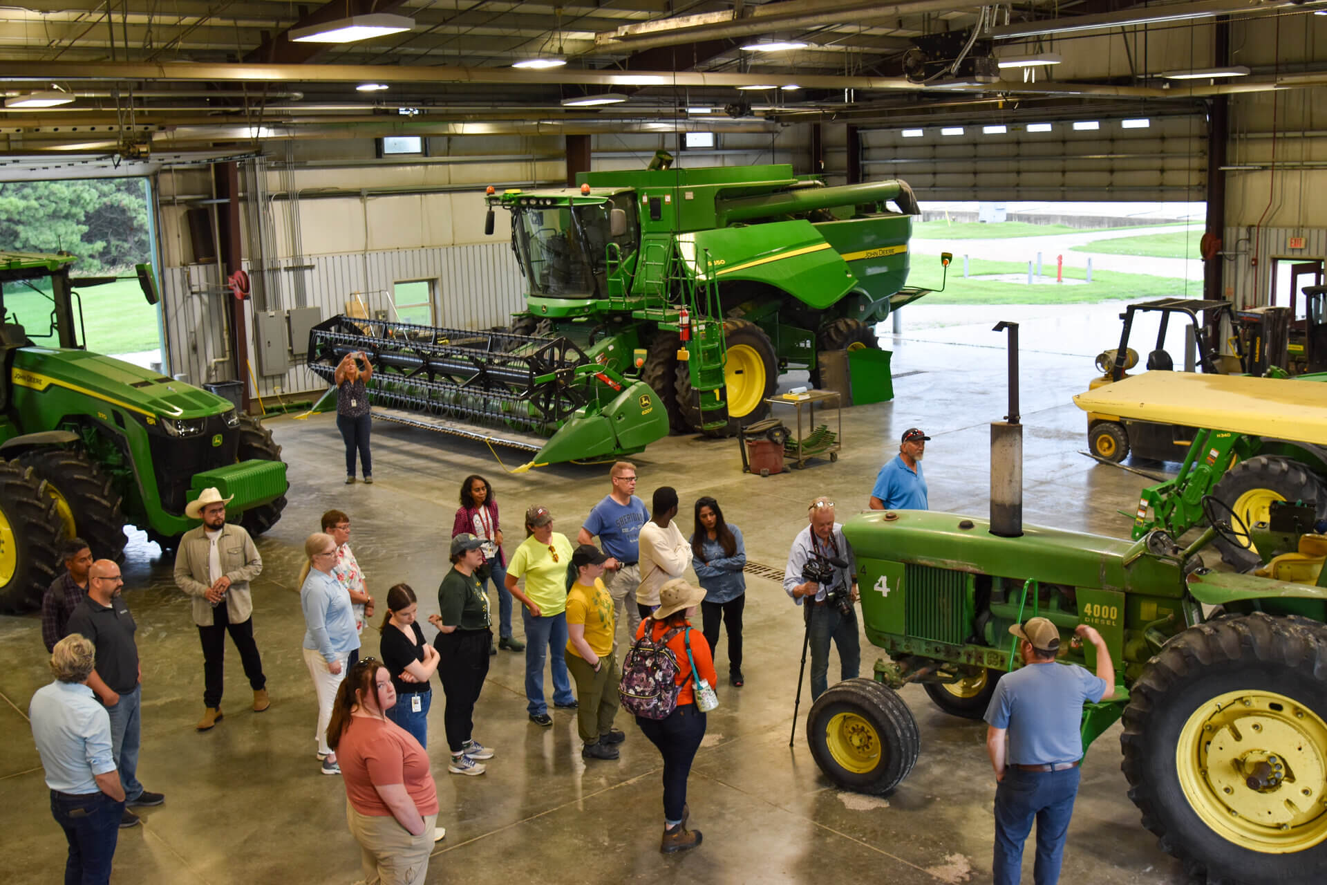 UNMC health care professionals group in farm shop learning about farm machinery 