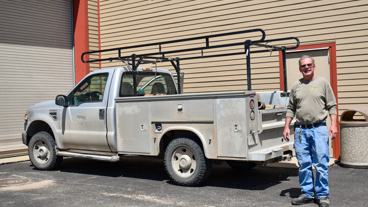 ENREEC Electrician Bryan Desh next to his work truck