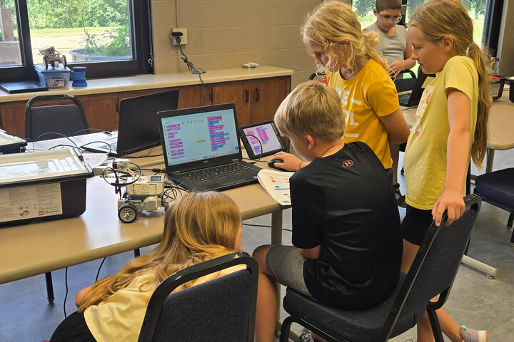 Youth gather around a computer during the robotics camp at Haskell Ag Lab.